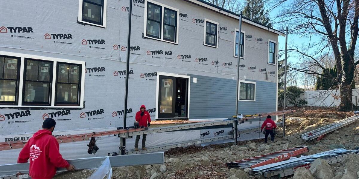Luminous Construction crew installing composite siding over TYPAR weather barrier in Marlborough MA