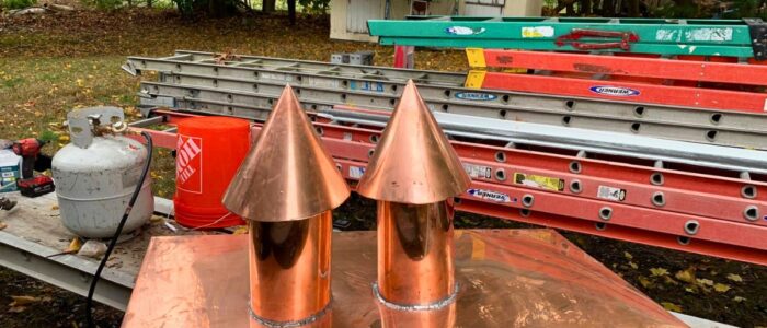 Custom handcrafted copper chimney caps and flashing prepared for rooftop installation