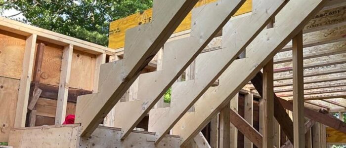 Precision cut wood staircase stringers installed in a timber-framed custom home