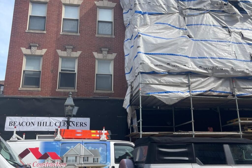 Historic brick building facade restoration with protective scaffolding containment in Beacon Hill Boston MA
