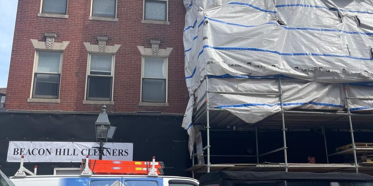 Scaffolding with protective weather containment tarp on historic brick building restoration project in Lincoln MA