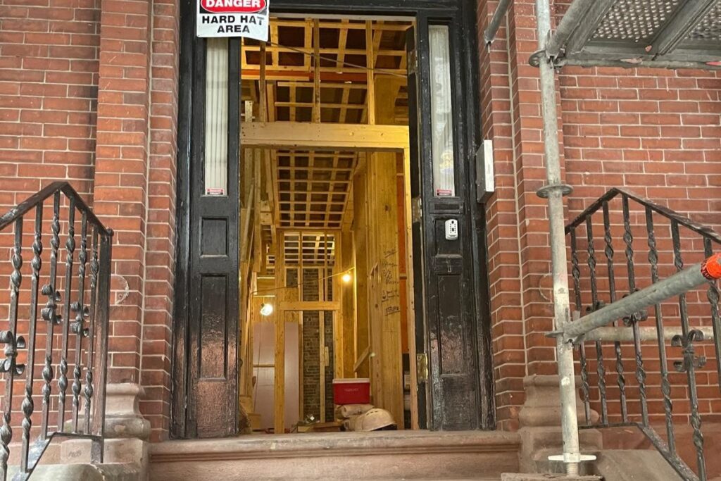 Historic brick brownstone entryway with active structural timber framing and interior restoration in Boston MA