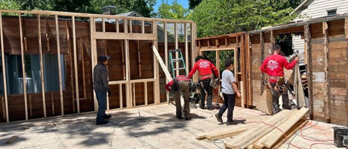 local-home-remodeling-contractor-massachusetts Luminous Construction crew working on structural wall framing and subfloor assembly for home renovation