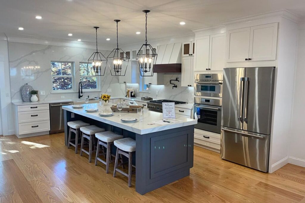 Luxury design build kitchen remodel in Natick MA with waterfall quartz island custom cabinetry and geometric pendant lighting