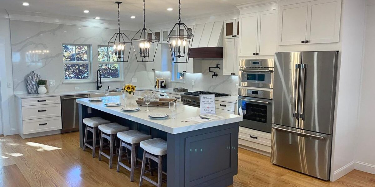 Open concept kitchen featuring a navy blue accent island, quartz countertops, and stainless steel appliances