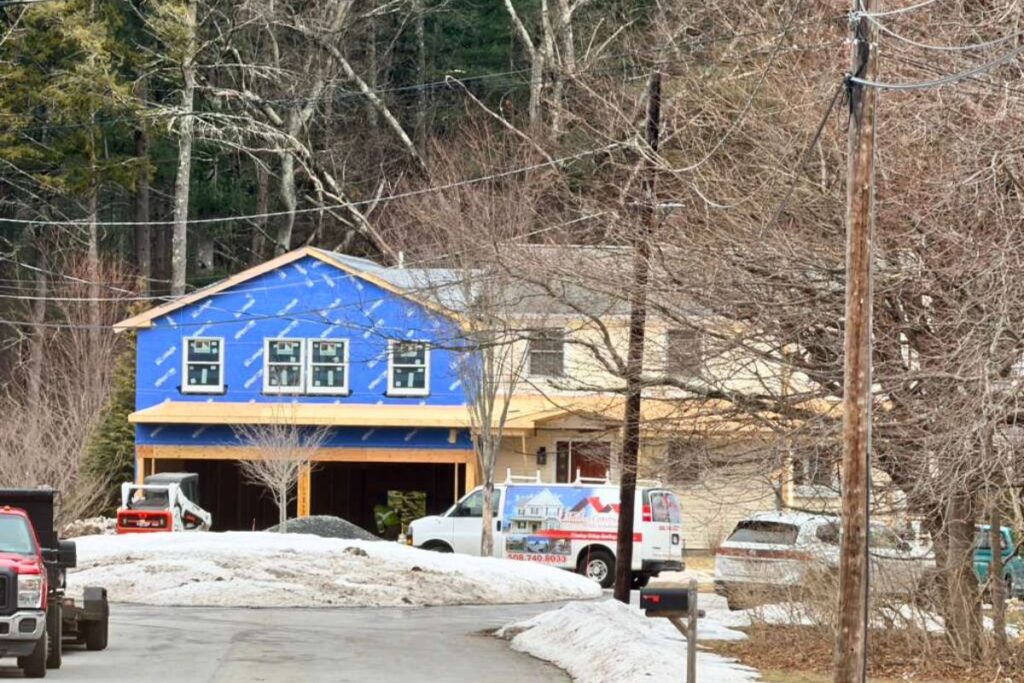 Two story custom home addition with weather barrier wrap and window installation in Wellesley MA
