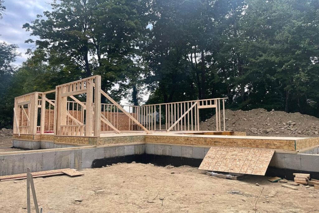 Poured concrete foundation walls and initial wood wall framing for custom addition in Concord MA