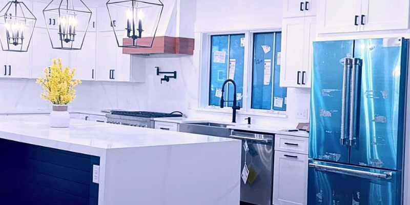 Gourmet kitchen remodeling with waterfall quartz island and custom lighting by general contractor in Wellesley MA